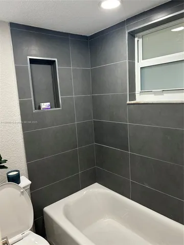 a white bath tub sitting next to a white toilet