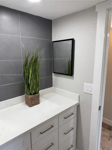a bathroom with a sink a vanity and a potted plant