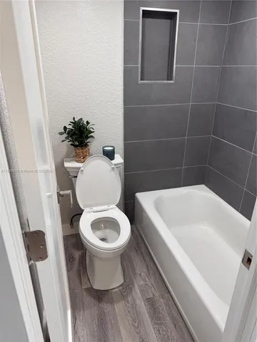 a white toilet sitting next to a white bath tub