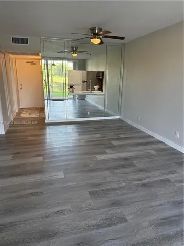 a view of a room with wooden floor and windows