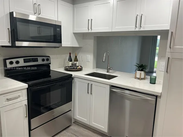 a kitchen with a sink stove and microwave
