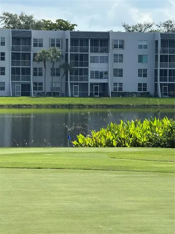 a view of a big house with a big yard and large trees