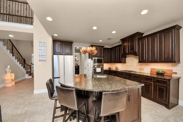 a kitchen with stainless steel appliances granite countertop a kitchen island a table and chairs