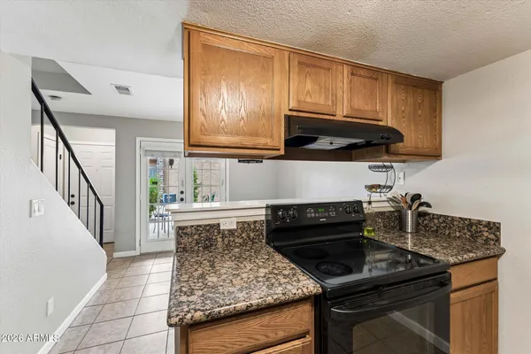 a kitchen with granite countertop a stove a sink dishwasher and cabinets with wooden floor