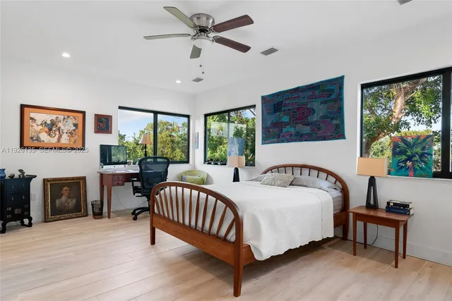 a bed sitting in a spacious bedroom next to a window