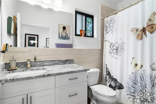 a bathroom with a granite countertop sink toilet and shower