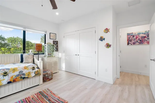 a bedroom with furniture and a large window