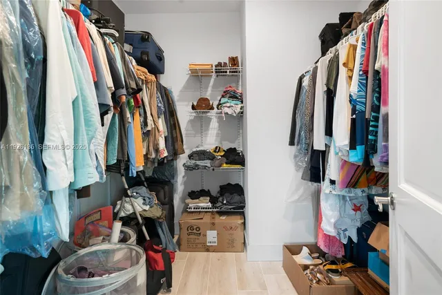 a view of walk in closet with clothes and shoes