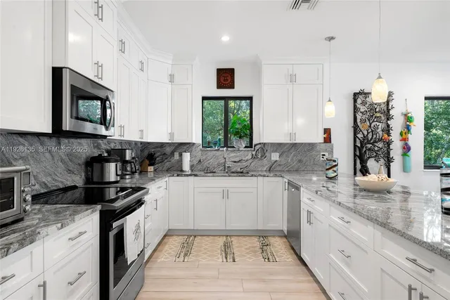 a kitchen with granite countertop a sink stove top oven and cabinets