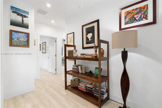 a room with painting on the wall and a lamp