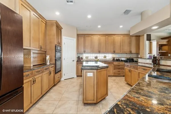 a kitchen with granite countertop a sink a counter top space stainless steel appliances and cabinets