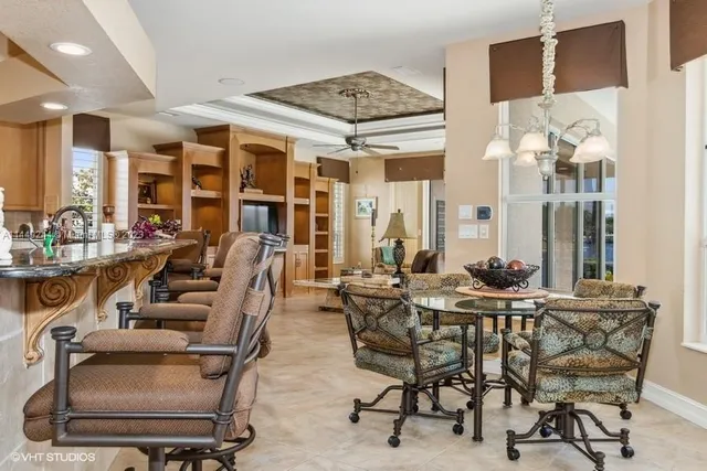 a dining room with furniture a chandelier and wooden floor
