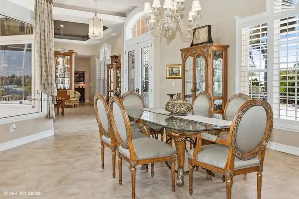 a dining room with furniture a chandelier and wooden floor