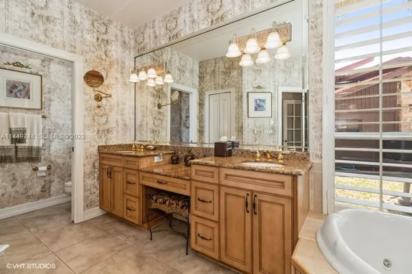 a spacious bathroom with a double vanity sink a mirror and a shower
