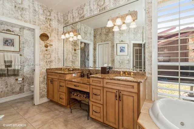 a bathroom with a granite countertop sink a mirror a bathtub and shower