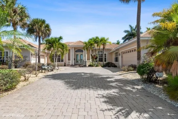 a view of a house with a yard and palm trees