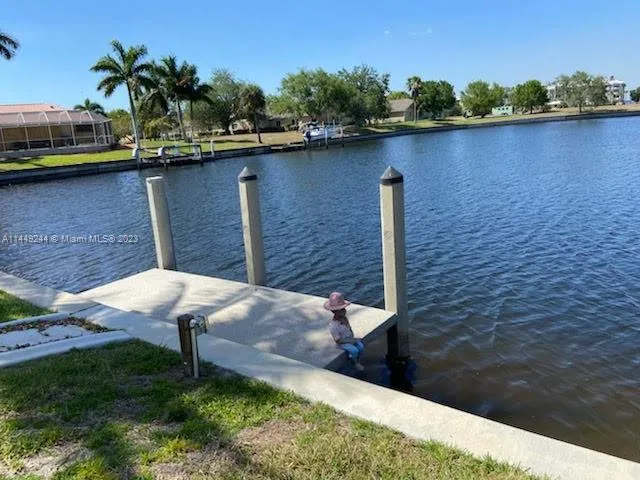 a view of a lake with a big yard and large trees