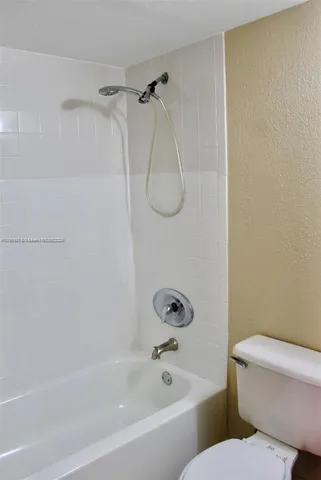 a bathroom with a toilet and a bath tub