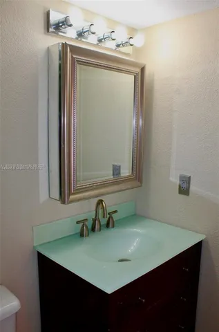 a bathroom with a sink vanity and a mirror