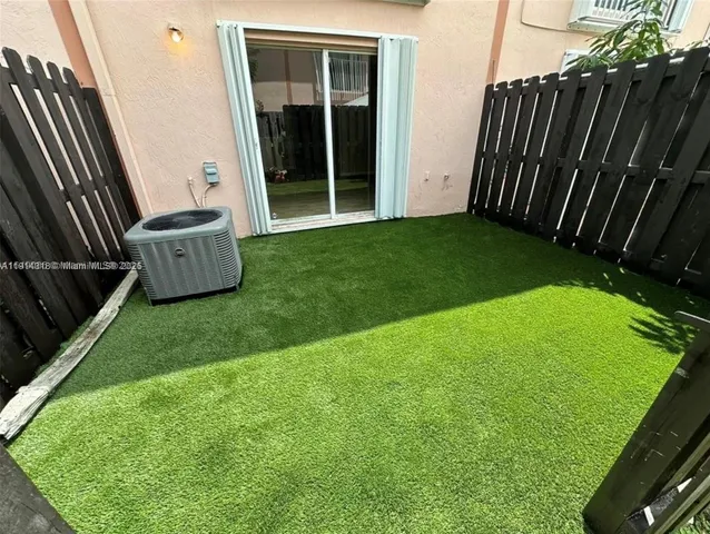 a backyard of a house with a garden and barbeque oven