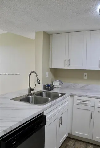 a kitchen with sink a stove and cabinets