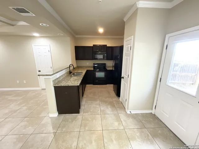 a kitchen with granite countertop a sink and a stove top oven