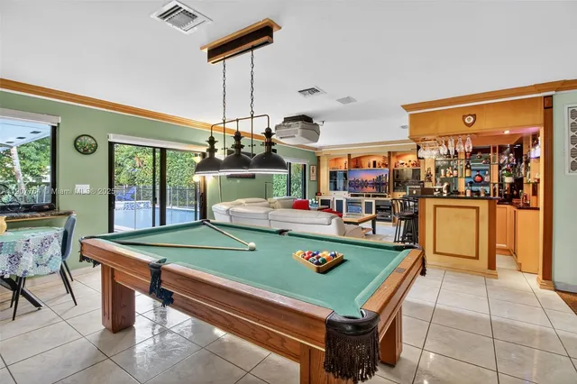 a room with pool table and a chandelier