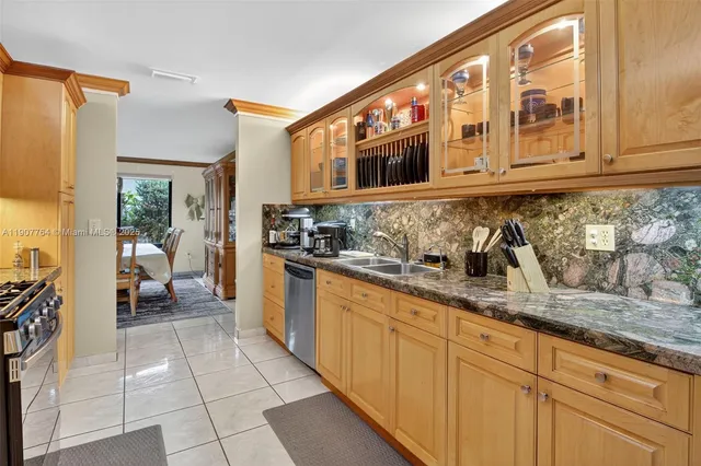 a kitchen with granite countertop white cabinets stainless steel appliances and a counter space
