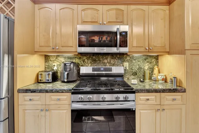 a kitchen with stainless steel appliances granite countertop a refrigerator and a stove