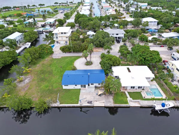 an aerial view of residential houses with outdoor space and parking