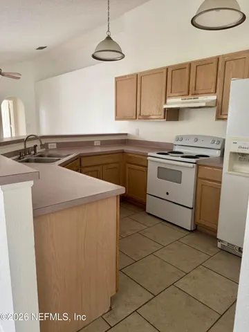 a kitchen with a sink a counter top space and cabinets