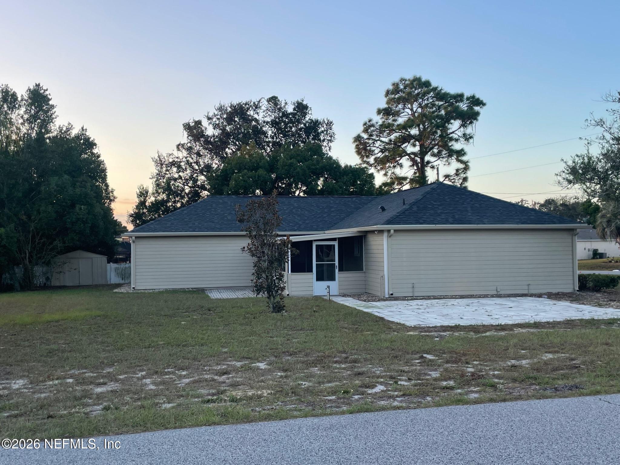 11447 Exmore Street Spring Hill, FL 34609 - Photo 6 of 31 a view of a yard in front of a house with large tree