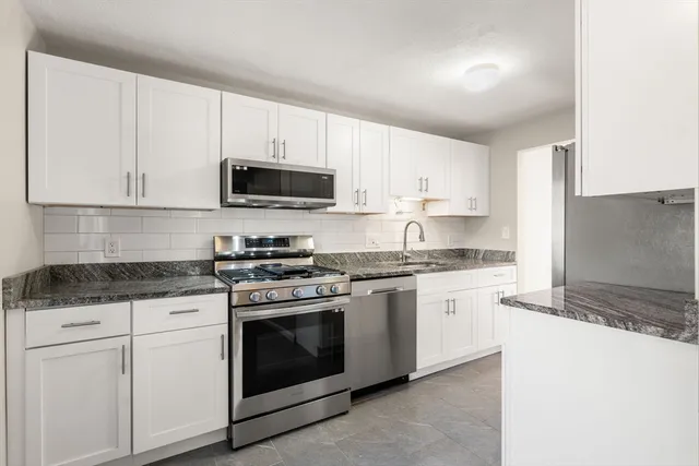 a kitchen with stainless steel appliances granite countertop a stove and a refrigerator