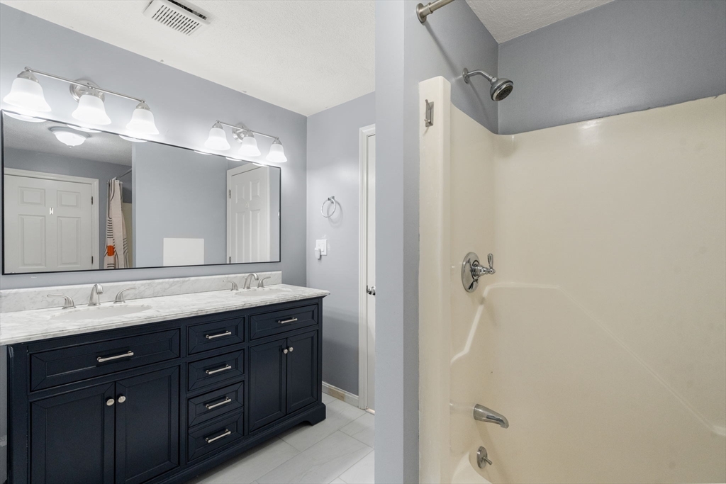 9 Oak Ridge Drive, Unit 6 Maynard, MA 01754 - Photo 24 of 39 a bathroom with a granite countertop sink mirror and a shower