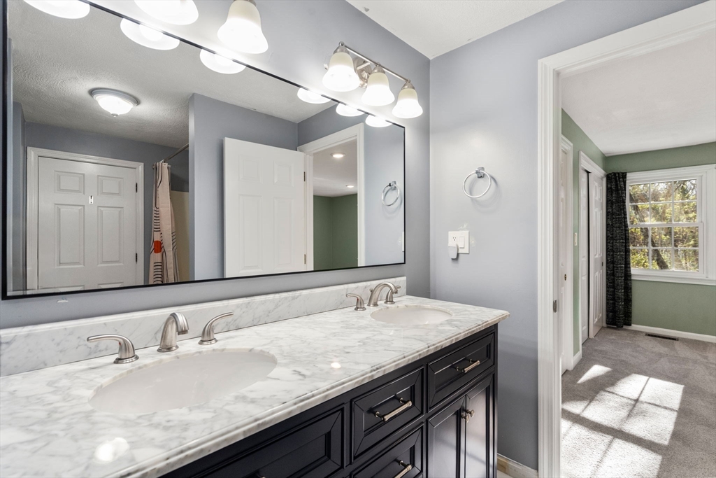 9 Oak Ridge Drive, Unit 6 Maynard, MA 01754 - Photo 25 of 39 a bathroom with a granite countertop sink a large mirror and a shower
