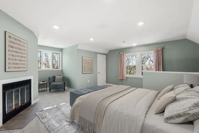 a bedroom with a large bed a chandelier and a window