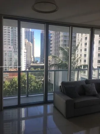 a living room with furniture and a floor to ceiling window