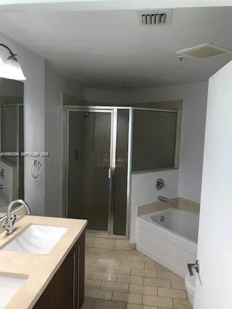 a bathroom with a granite countertop sink a mirror and a bathtub