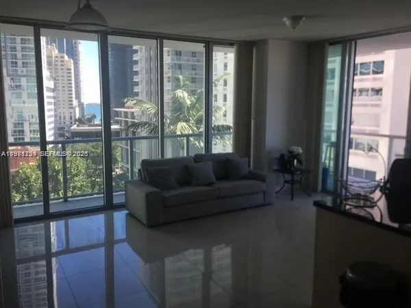 a living room with furniture and a floor to ceiling window