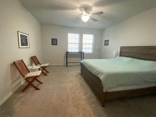 a bedroom with a bed a chair and a chandelier