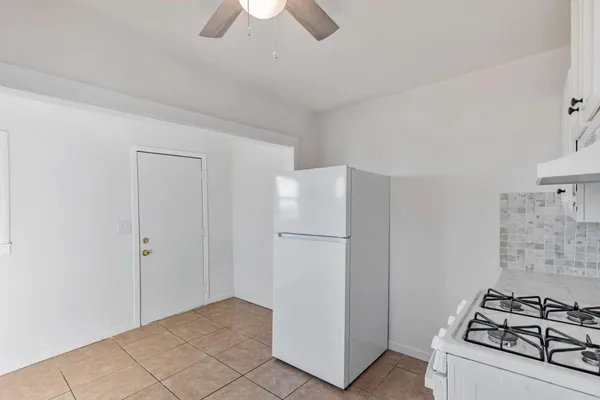 a view of kitchen with refrigerator stove and cabinets