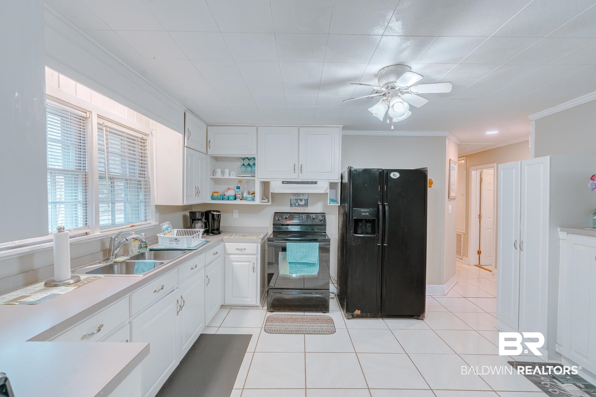 315 Fourth Avenue Chickasaw, AL 36611 - Photo 18 of 28 Kitchen with a sink, ornamental molding, open shelves, black appliances, and a ceiling fan
