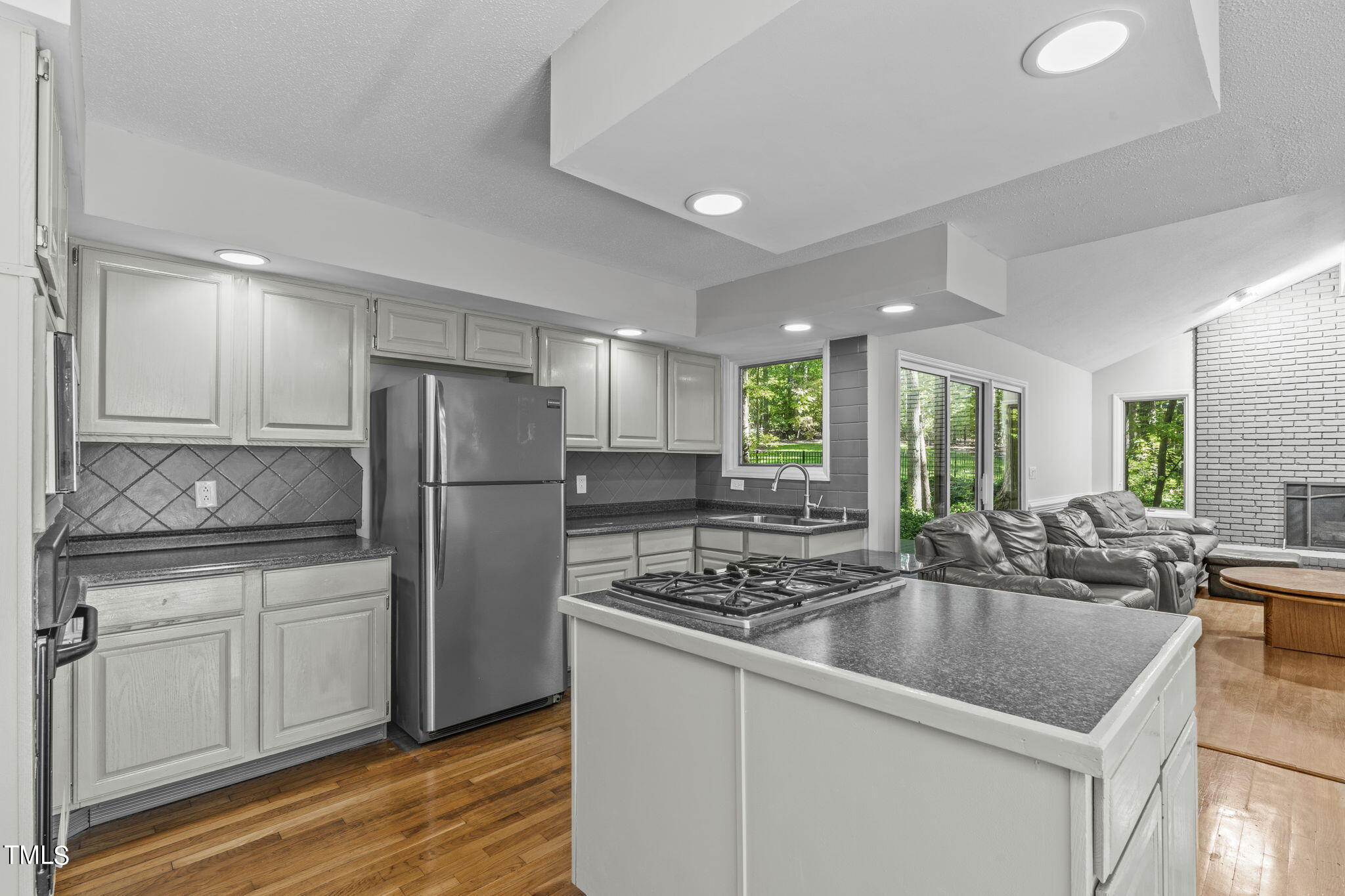 404 King George Loop Cary, NC 27511 - Photo 24 of 60 a kitchen with stainless steel appliances granite countertop a sink a stove a refrigerator and island with wooden floor