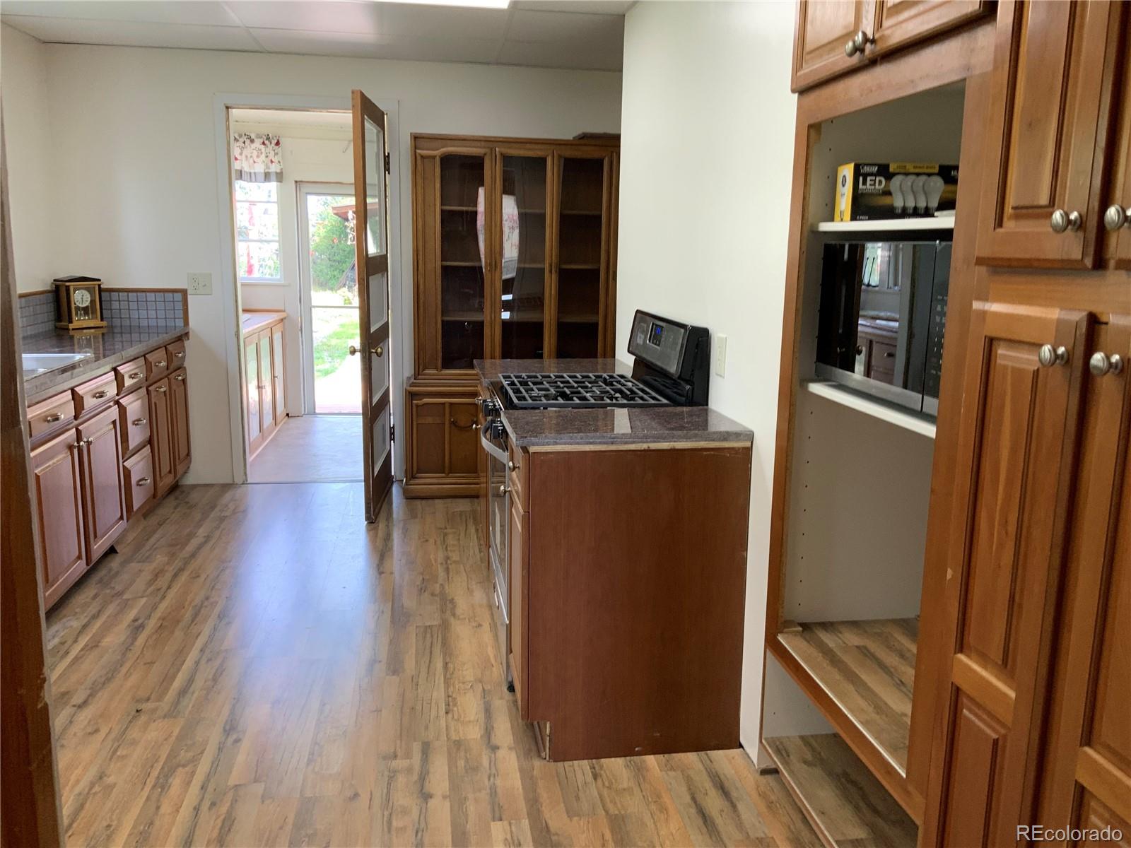 1011 Main Street Meeker, CO 81641 - Photo 3 of 28 a kitchen with stainless steel appliances granite countertop wooden floors and sink