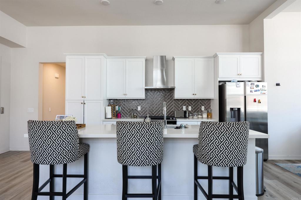 2040 Bravo Loop, Unit 5 Chula Vista, CA 91915 - Photo 33 of 58 a kitchen with stainless steel appliances granite countertop a dining table chairs and a refrigerator