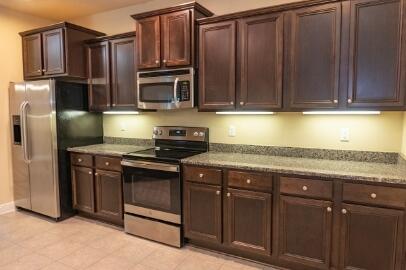 509 Pheasant Trail Crestview, FL 32536 - Photo 9 of 29 a kitchen with granite countertop wooden cabinets and stainless steel appliances