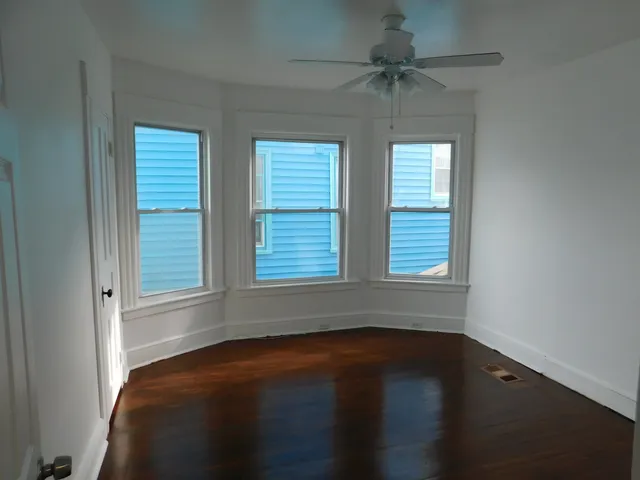 a view of a livingroom with a fan and a window