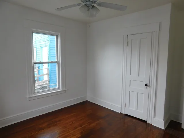 an empty room with a window and a ceiling fan