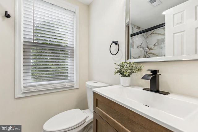 a bathroom with a sink a toilet and a window
