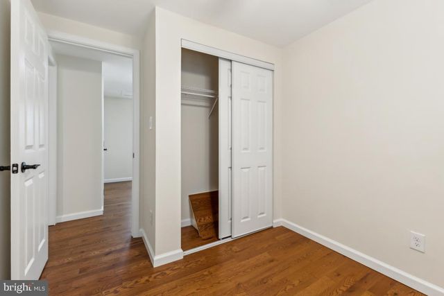 an empty room with wooden floor and entrance
